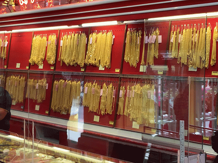 Gold jewelry on display on a retail shop counter, around Sam Yoot, Bangkok