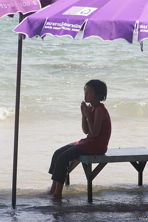 Young Girl waiing or praying. On Hua Hin Beach, Thailand